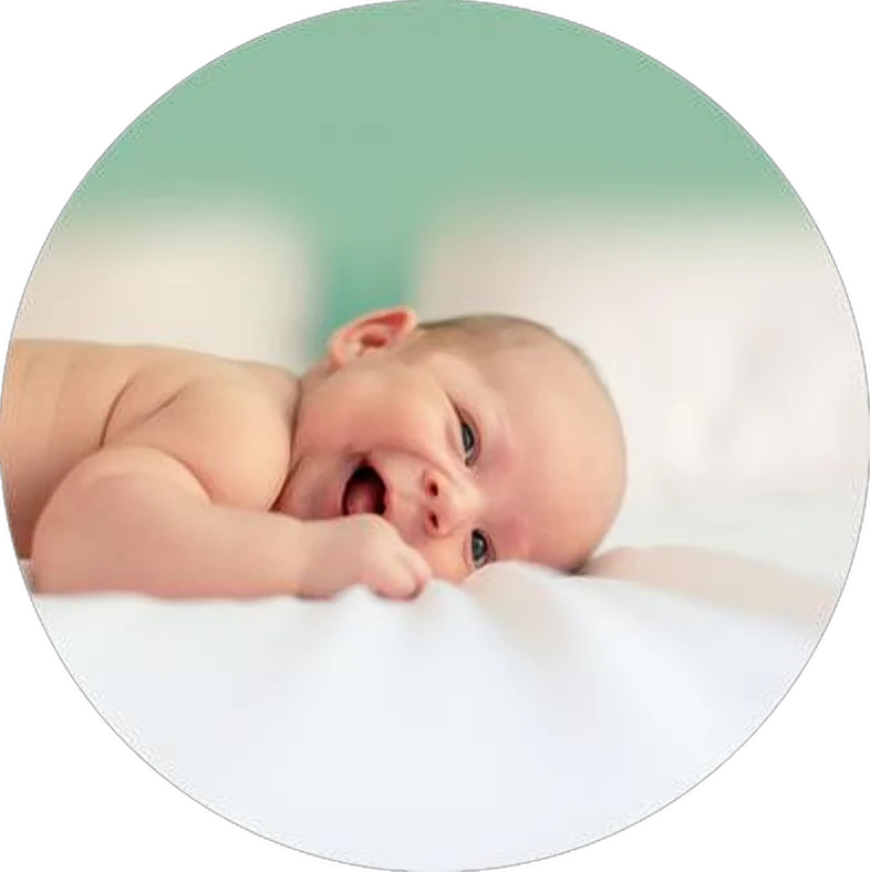 A newborn baby lying on white sheets
